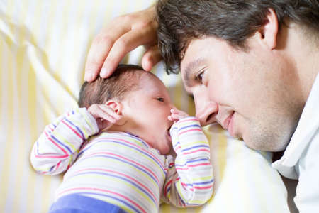 Young father hugging his newborn daughter 