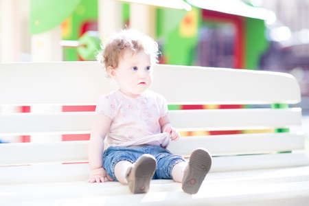 Beautiful baby girl enjoying the sun on a playground の写真素材