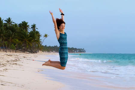 Young beautiful woman jumping on a tropical beach の写真素材