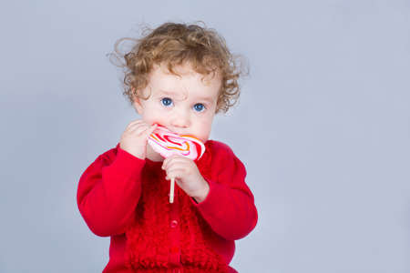 Cute baby girl with a heart shaped candy 