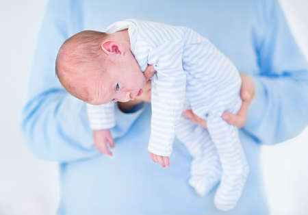 Sweet newborn baby sleeping in his father s arms の写真素材