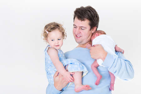 Young father holding a cute curly toddler girl and a newborn baby の写真素材