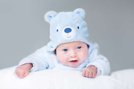 Portrait of a cute newborn baby boy in a teddy bear hat の写真素材