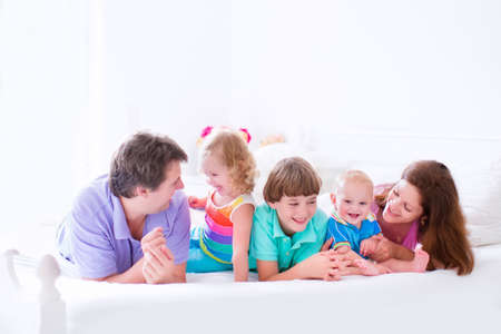 Happy big family, young parents with three kids, laughing boy, cute toddler girl and adorable little...
