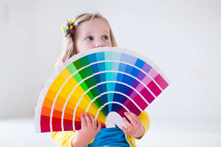 Family remodeling house. Home remodel and renovation. Kids painting walls with colorful brush and...