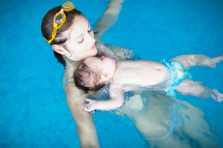 Mother and baby relaxing in a swimming poolの写真素材