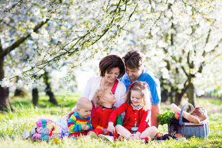 Big family with three little children eating lunch outdoors.の写真素材