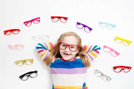 Child at eye sight test. Little kid selecting glasses at optician store. Eyesight measurement for school kids. Eye wear for children. Doctor performing eye check. Girl with spectacles at letter chart.の写真素材