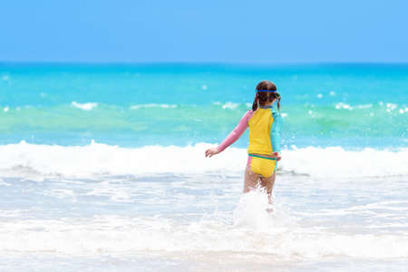 Child playing on tropical beach. Little boy digging sand at sea shore. Family summer vacation. Kids play with water and sand toys. Ocean and island fun. Travel with young children. Asia holiday.の写真素材