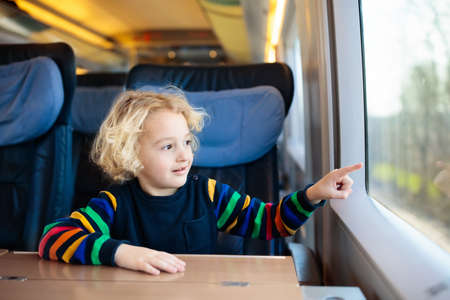 Child traveling by train. Little kid in a high speed express train on family vacation in Europe. Travel by railway. Children in railroad car. Kids in rail way wagon. Entertainment for young passenger.の写真素材