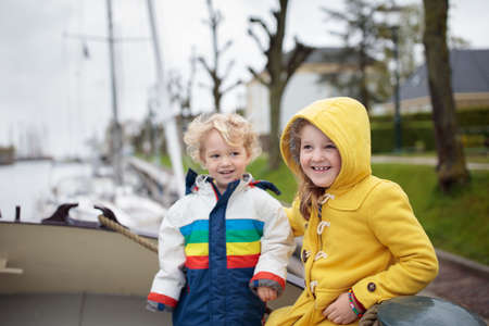 Family on boat in Holland, sailing in Amsterdam channels. Dutch family with kids on traditional residential yacht. Wooden ship in the Netherlands.の写真素材