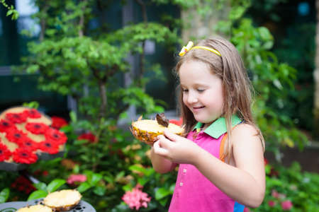 Child watching butterfly at tropical garden. Little girl feeding exotic butterflies at Asian zoo. Butterfly garden at Changi airport, Singapore. Kids and animals.の写真素材
