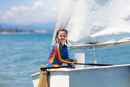 Child sailing. Kid learning to sail on sea yacht. Healthy water sport for school kids. Yachting class for young sailor. Children on boat. Family summer vacation on tropical island. Beach activity.の写真素材