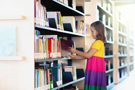 Child in school library. Kids read books. Little girl and boy reading and studying. Children at book...
