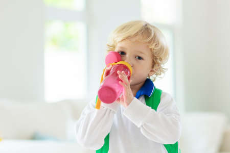 Child going back to school. Kid getting ready for first school day after vacation. Little boy on his way to kindergarten or preschool. Student packing books, apple and lunch in backpack.の写真素材