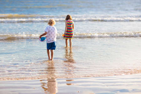 Child playing on tropical beach. Little boy with bucket and spade at seashore. Family summer vacation. Kid building sandcastle. Kids search for shells and play. Water and sand fun for children.の写真素材