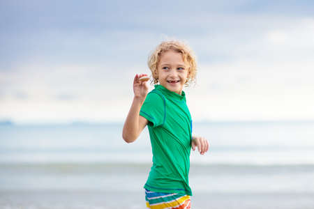 Child playing on tropical beach. Little baby boy at sea shore. Family summer vacation. Kids play...
