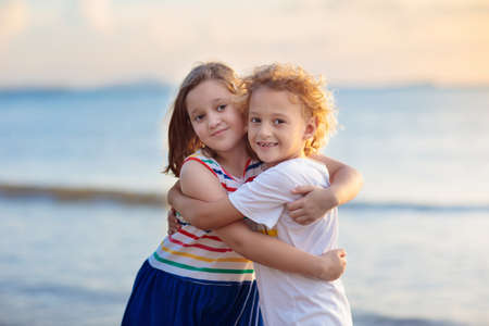Child playing on tropical beach. Little boy and girl at sea shore. Family summer vacation. Kids play with water and sand toys. Ocean and island fun. Travel with young children in Asia.の写真素材