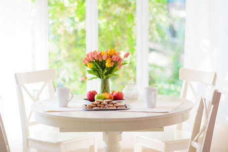 Homemade cookies on breakfast table in white sunny dining room or kitchen. Fruit and pastry for tea party. Fresh baked lemon cookie pile.の写真素材