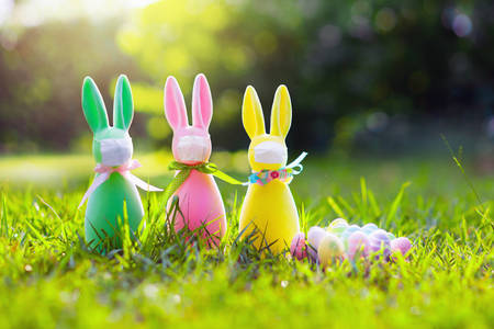 Easter bunny in face mask during coronavirus outbreak. Decoration and celebration during global...