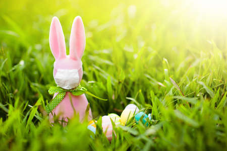 Easter bunny in face mask during coronavirus outbreak. Decoration and celebration during global...