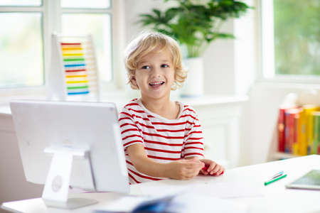 Online remote learning. School kids with computer having video conference chat with teacher and class group. Child studying from home. Homeschooling during quarantine and coronavirus outbreak.の写真素材