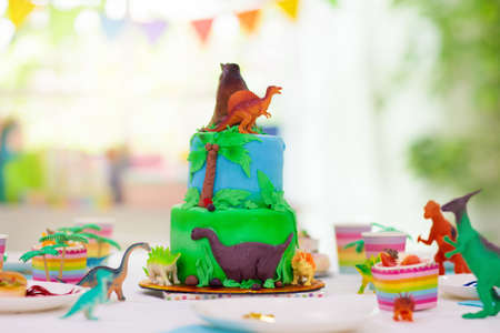 Kids birthday party. Dinosaur theme layer cake. Children event. Decoration for dinosaurs themed celebration.の写真素材