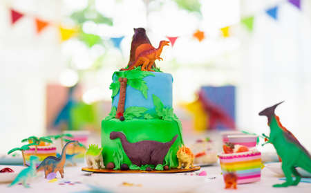 Kids birthday party. Dinosaur theme layer cake. Children event. Decoration for dinosaurs themed celebration.の写真素材