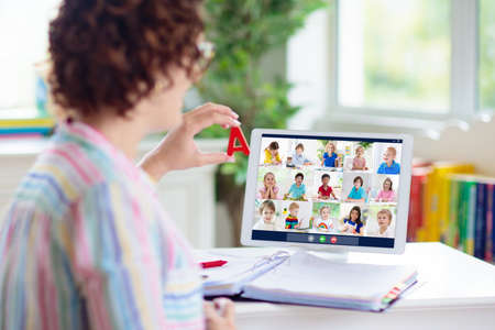 Online remote learning. Teacher with computer having video conference chat with student and class...