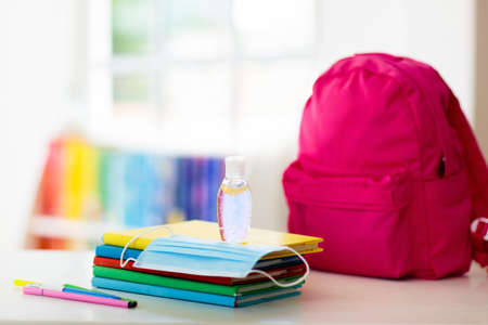 Backpack of school child with face mask and sanitizer. Student safety after coronavirus pandemic....