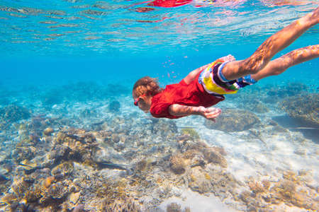 Child snorkeling. Kids swim underwater. Beach and sea summer vacation with children. Little girl...