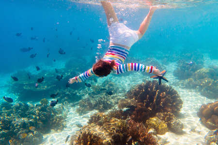 Child snorkeling. Kids swim underwater. Beach and sea summer vacation with children. Little girl...