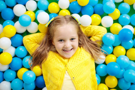Child playing in ball pit. Colorful toys for kids. Kindergarten or preschool play room. Toddler kid...