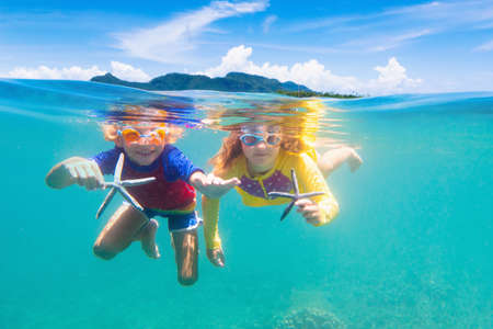 Child snorkeling. Kids swim underwater. Beach and sea summer vacation with children. Little girl watching coral reef fish. Marine life on exotic island. Kid swimming and diving with snorkel and mask.の写真素材