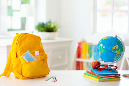 Backpack of school child with face mask and sanitizer. Student safety after pandemic. Virus and disease prevention for kids. Back to school and kindergarten after outbreak.の写真素材
