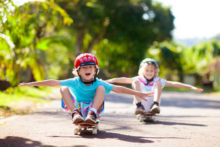 Kid with skateboard. Child riding skate board. Healthy sport and outdoor activity for school kids in...