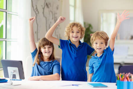 Online remote learning. School kids with computer having video conference chat with teacher and class group. Child studying from home. Homeschooling during quarantine and coronavirus outbreak.の写真素材