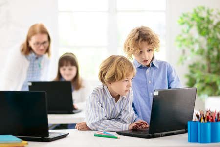 School children with laptop computer. Video conference chat with teacher and student class group....
