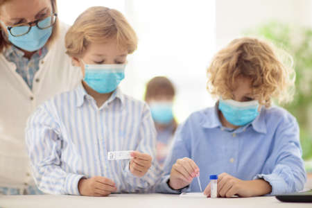 test in school. Rapid antigen testing for students in classroom. Kid doing swab test kit in class....