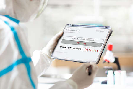 Omicron variant of covid 19 testing. Coronavirus test in hospital laboratory. Doctor analyzing patient blood and nasal swab sample for new covid-19 mutation. Pandemic prevention. Clinical research.の写真素材