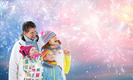 Happy new year. Family watching fireworks. Parents and kids celebrate new 2022 year. Winter holiday...