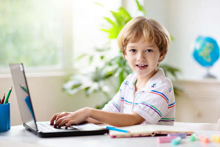 Online remote learning. School kids with computer having video conference chat with teacher and class group. Child studying from home. Homeschooling during quarantine and coronavirus outbreak.の写真素材