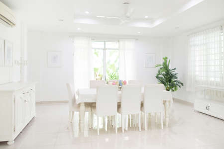 home interior. Dining room design. Table and chairs in white sunny house. Kitchen breakfast area in family apartment.の写真素材