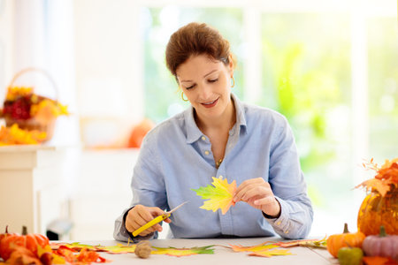 autumn home decoration. Family decorating house with colorful maple leaves banner. Thanksgiving or...