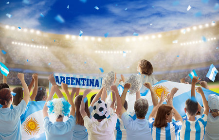 Argentina football supporter on stadium. Argentinian fans on soccer pitch watch team play. Group of supporters with flag and national jersey cheering for Argentina. championship game. Vamos Argentinaの写真素材