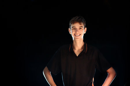 Teenager in black shirt on dark background. young athletic man. Studio portrait of fit athlete. college student. Teen boy.の写真素材