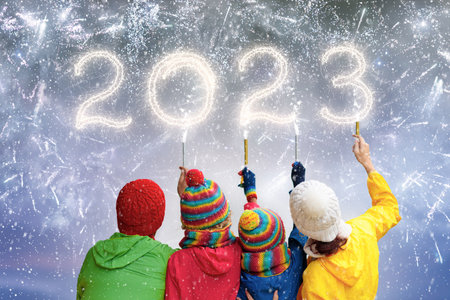 happy new year. Family watching fireworks. Parents and kids celebrate new year 2023. Winter holiday party. outdoor fun. Children, mother and father with sparkler watch firework show.の写真素材