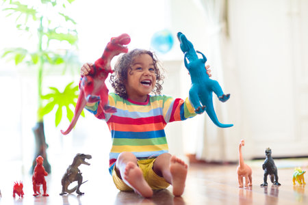 Child playing with colorful toy dinosaurs. Educational toys for kids. Little boy learning fossils and reptiles. Children play with dinosaur toys. Evolution and paleontology game for young kid.の写真素材