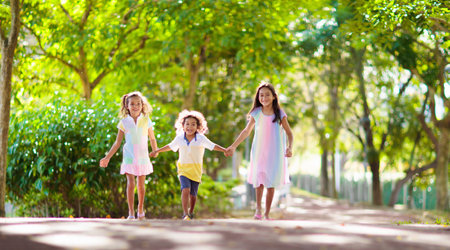 Happy kids play in summer park. Children run and laugh. summer holiday fun. Boy and girl playing outside. school holiday activity. Siblings love. kid on playground. Little child outdoor game.の写真素材