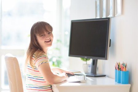 Child doing homework on computer. online class. homeschooling and remote learning. Little school girl reading on monitor screen. Kids play video game. Gaming and screen time control.の写真素材